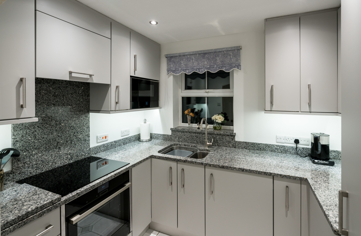 Small modern kitchen in apartment with granite worktop