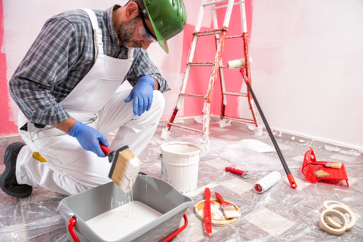 House painter worker at work in the construction site. Building.