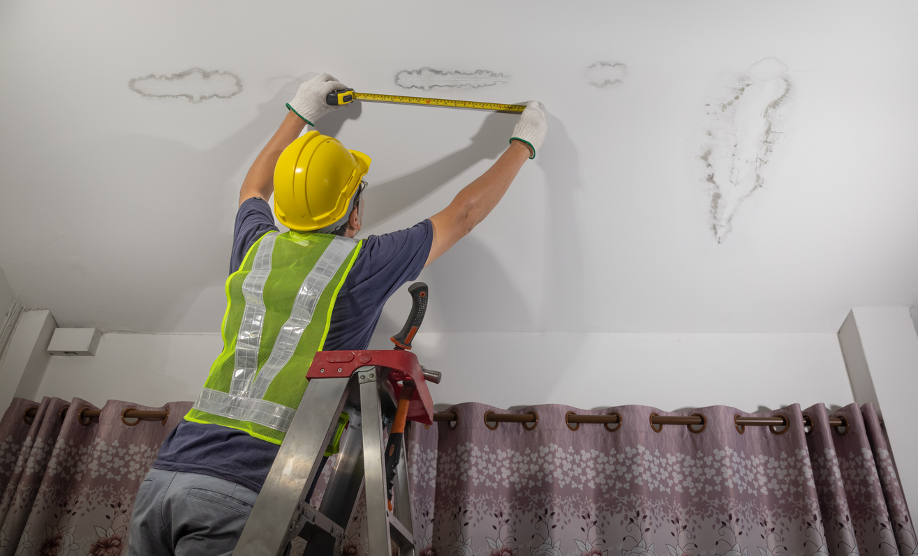 Worker fix leaking pipe in ceiling